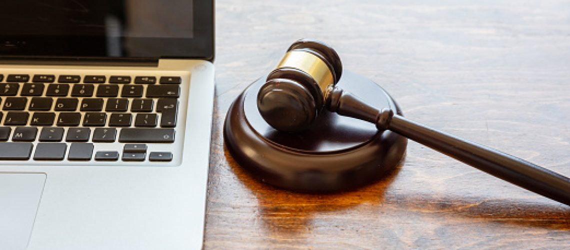 Auction law gavel and a computer laptop, wooden office desk background, closeup view, Online auction, cyber crime  concept